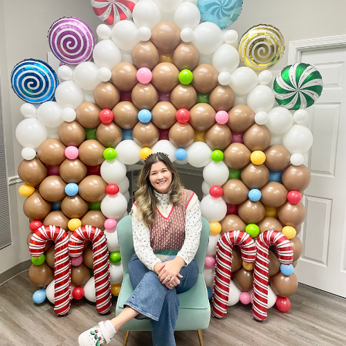 Owner Elizabeth Randau and a custom Balloon Gingerbread House