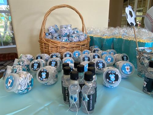 Assortment of custom designed baby shower favors, candy mini jar bottles, mini liquor bottles adorned with wax seal stamp.