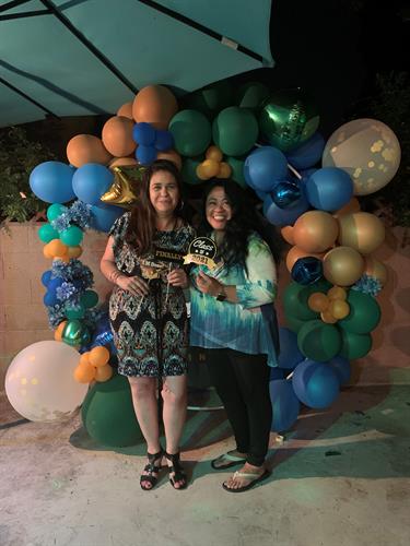 Graduation circle balloon arch created as a backdrop for a photo booth prop, using 5", 11" and 36" balloons in metallic gold, blue and green to match the school colors.
