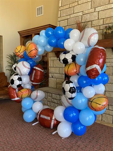 Party Over Here offers balloons to create a DIY balloon arch. Football Baseball Basketball Soccer Balloon circle arch using baby blue, royal blue and white balloons for a baby shower.