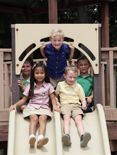Kindergarten students take a break from the classroom to have some fun time on the playground.  