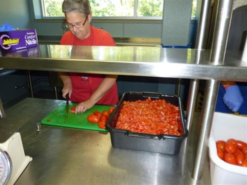 Volunteer Processesing Donated Tomatoes