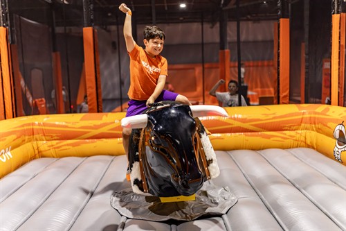 Kids riding a mechanical bull at Big Air Plano, a fun indoor attraction for families and birthday parties in Plano, TX