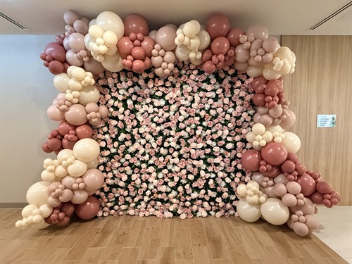 Elegant pink rose flower wall with custom balloon decor.