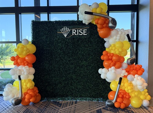 Golf-themed corporate balloon backdrop with custom golf club accents.