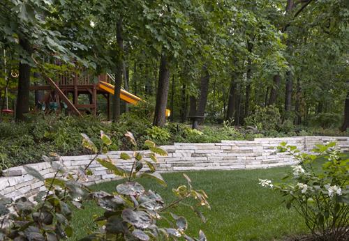 Terracing this backyard with natural stone walls created a usable lawn while keeping the woodsy features of the property.