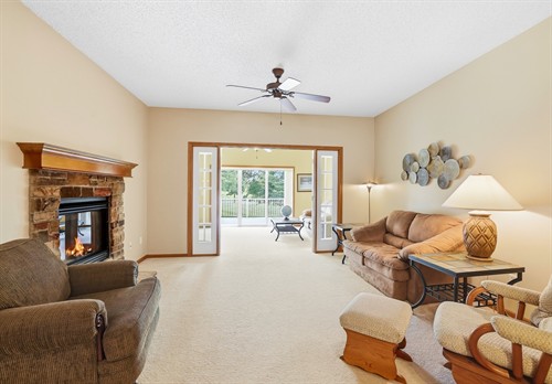 Warm & inviting interior with fireplace leading to a sunroom - 776 Meredith Cir, River Falls