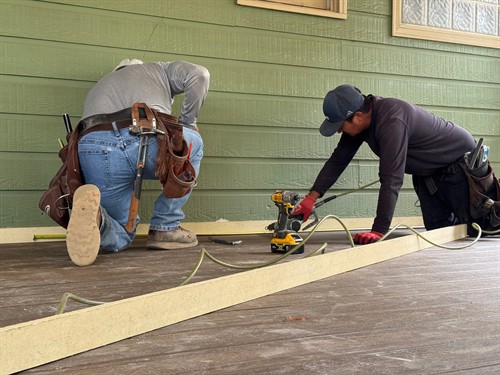 Professional deck builders at Hoover Deck & Porch installing durable composite floor boards on a custom deck frame in Hoover, Alabama.