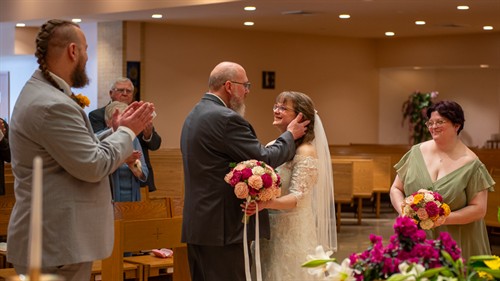 Couple embracing after exchanging vows during a Catholic Wedding Mass in Hartford, Wisconsin. Steve Sweeney Photography