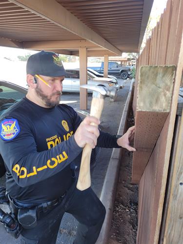 Officer fixing a victim's broken patio gate