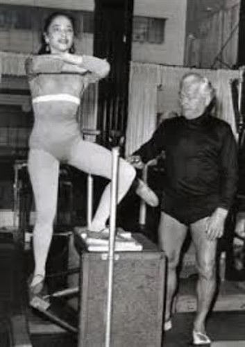 Joseph Pilates working with a student on the Wunda Chair, demonstrating how strength, balance & coordination come together through purposeful movement.