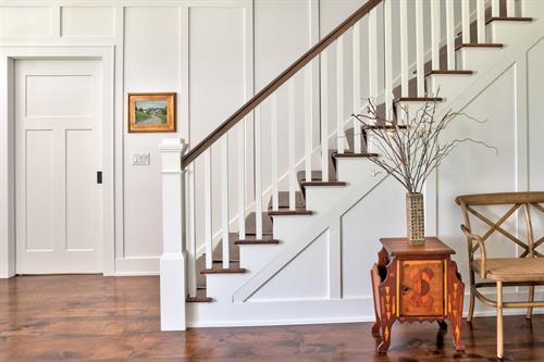 A stunning staircase is set off with wainscot walls