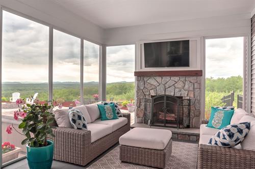 Screened porch with fireplace and mountain views beyond