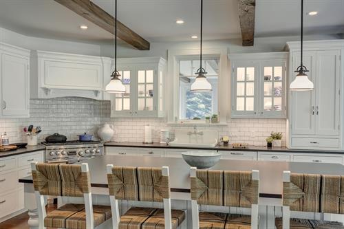 A country kitchen sporting white subway tile and exposed beams