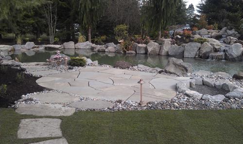 Patio, pond and waterfall by Greenhaven Landscapes