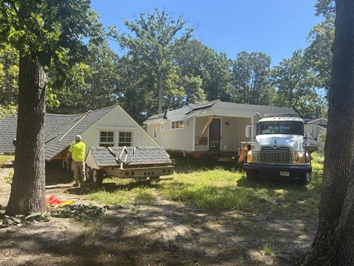 House move in progress. SJ Hauck has pioneered the technique of cutting the roof off in order to transport a house