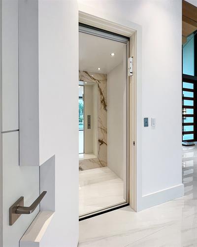 Custom built home elevator with mirror panel and mable to match the home's aesthetic.