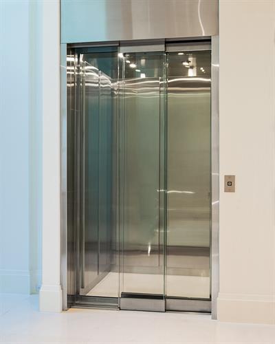 Custom built home elevator with glass doors.