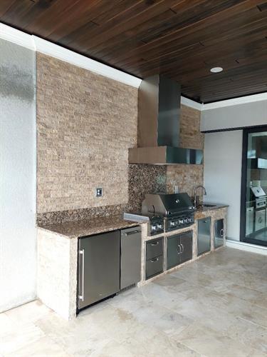 Custom concrete cabinet with stack stone on face and rear wall, stainless stell chase.