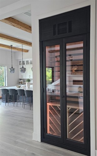 A refrigerated wine wall replaced a coat closet.