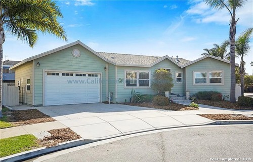 California Modular Houses. Pre fabricated homes.  Modular houses for California.  Casas modulares.  Coastal California.   A single-story house painted light blue with white trim, a two-car garage, and a front yard.  