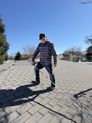 Mike Cawood measuring customer's roof for a free estimate