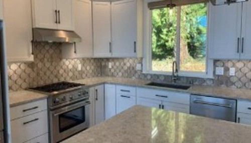 Luxury kitchen remodel with custom cabinets, decorative backsplash, and premium countertop installation by Alderwood Builders LLC in Whatcom County. 