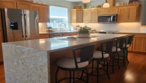 Custom granite kitchen island with natural stone countertops installed by NW Granite & Flooring.
