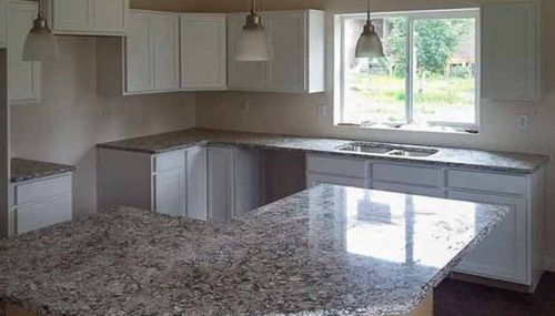 White kitchen cabinets paired with premium quartz countertops installed by NW Granite & Flooring.