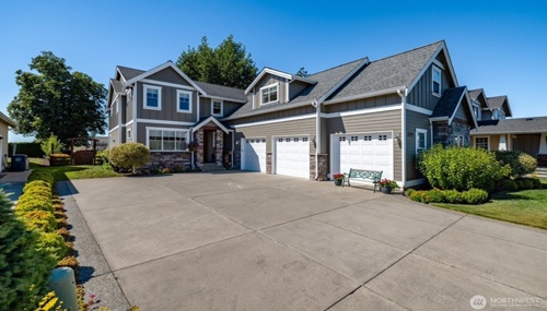 Spacious suburban home in Lynden, WA with three-car garage, large driveway, and beautifully landscaped yard.