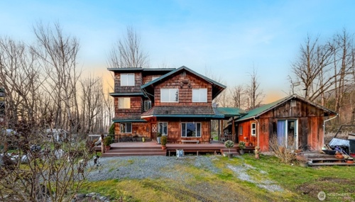 Rustic farmhouse property in Everson, WA with additional outbuilding and scenic rural surroundings.