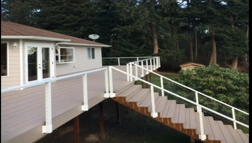 Custom elevated deck and cable railing installation completed by Triple C Construction Services LLC, creating a safe, durable, and attractive outdoor living space for a homeowner in Oak Harbor, WA