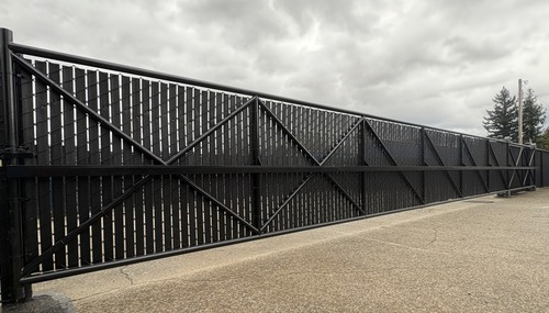 Commercial chain-link privacy gate with black privacy slats installed by C&W Fencing in Skagit or Island County, WA.