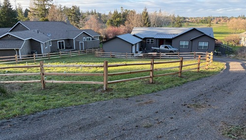 Split rail fence installation by C&W Fencing, providing an attractive boundary for a residential property in Skagit County, WA.