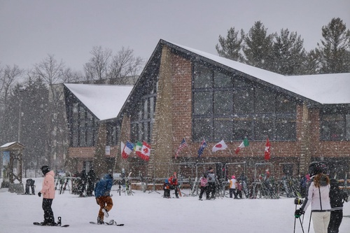 Outdoor view of cabin with people skiing in winter