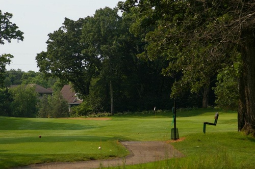 View of golf course with a paved path in the middle