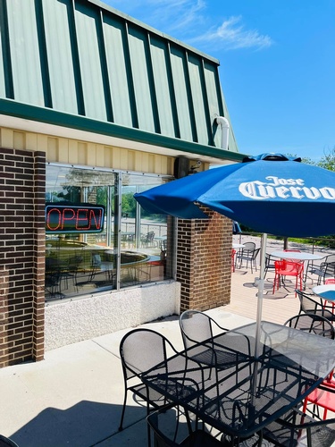 Outdoor seating facing the building at Riviera Bowl & Pizzeria