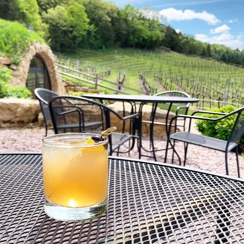 Cocktail on outdoor patio table with the view of grapevines at Wollersheim Winery
