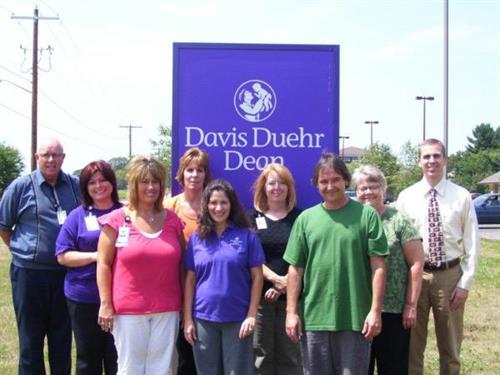 Employee group shot outside in front of sign at Davis Duehr Dean