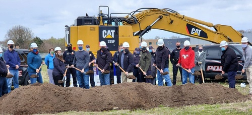 Group of employees holding shovels with dirt