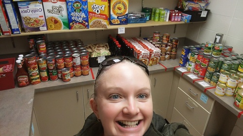 Volunteer showing off the canned goods at the Sauk Prairie food pantry