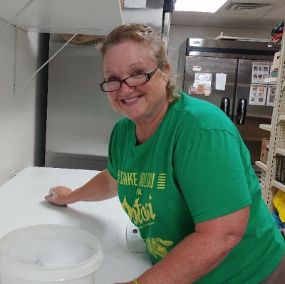 Volunteer smiling while cleaning at the sauk prairie food pantry