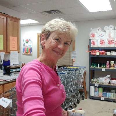 Volunteer smiling while helping at the sauk prairie food pantry