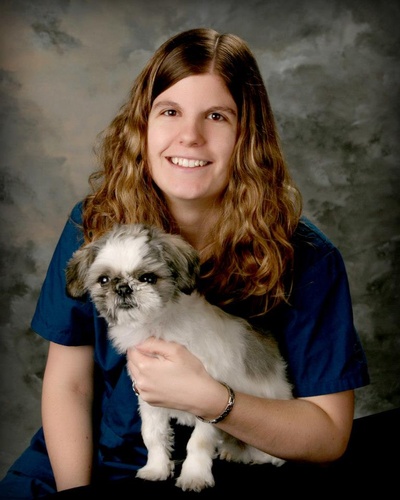 female employee holding a dog at four paws veterinary clinic