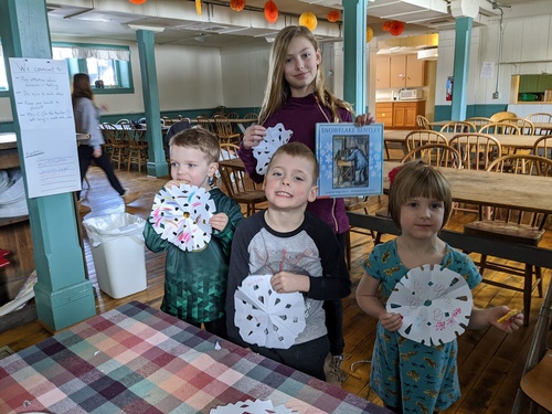 kids holding art decorations inside church