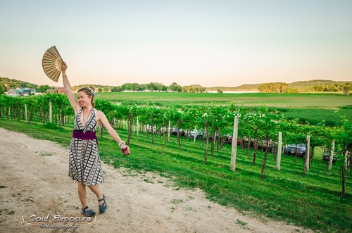 Woman dancing on gravel path in front of the grapevines at The Vines