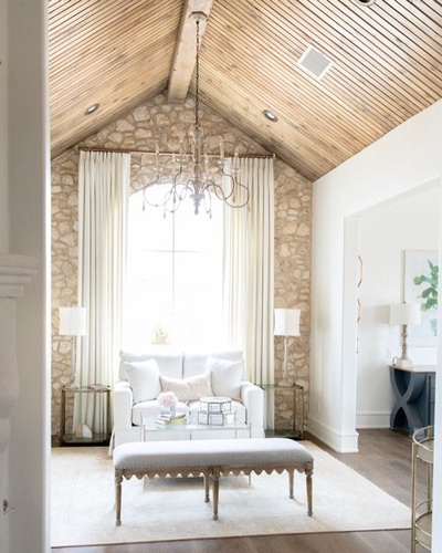 This design encompasses the perfect balance of rustic and traditional with the beautiful stone feature, rich wood ceiling, clean white wall, and classic draperies.