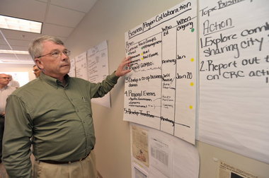 Bob Higgins, vice president of Baldwin County Economic Development Alliance, looks over an action chart during the War Room meeting at Meyer Real Estate in Gulf Shores on March 17. Gulf Coast Business/John Hauge