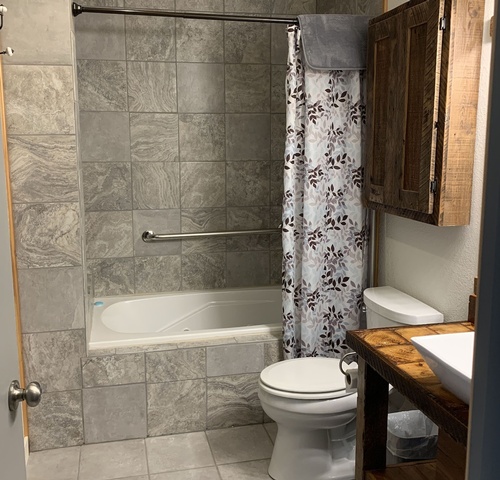  Upstairs bath has jetted tub and shower. Reclaimed wood cabinet over stool. Upstairs bath has jetted tub and shower. Reclaimed wood cabinet over stool., expand to full screen view Upstairs bath has jetted tub and shower. Reclaimed wood cabinet over stool.