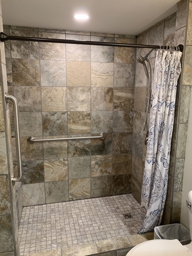 Lower level tiled walk-in shower features two shower heads.